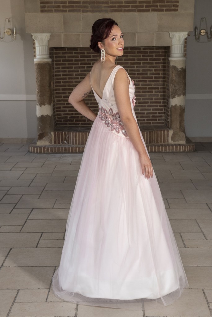 Robe de mariée rose poudrée agrémentée de broderies aux nuances de rose et réalisée dans un satin duchesse et tulle.