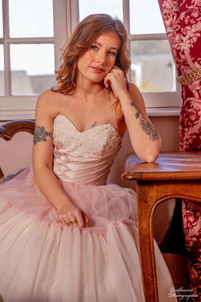 Robe de mariée rose poudrée. Un bustier en satin duchesse plissé et sa dentelle rebrodée perlée. Une juste subtilement dégradée de nuances de rose.