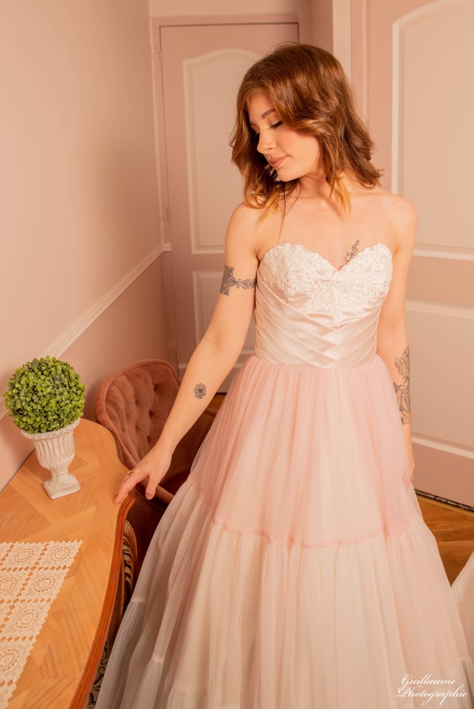 Robe de mariée rose poudrée. Un bustier en satin duchesse plissé et sa dentelle rebrodée perlée. Une juste subtilement dégradée de nuances de rose.