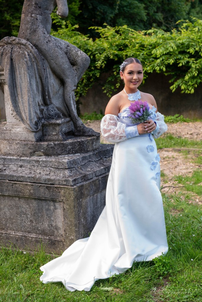 Robe de mariée en satin duchesse blanc cassé et doupion lavande, ornée de fleurs.