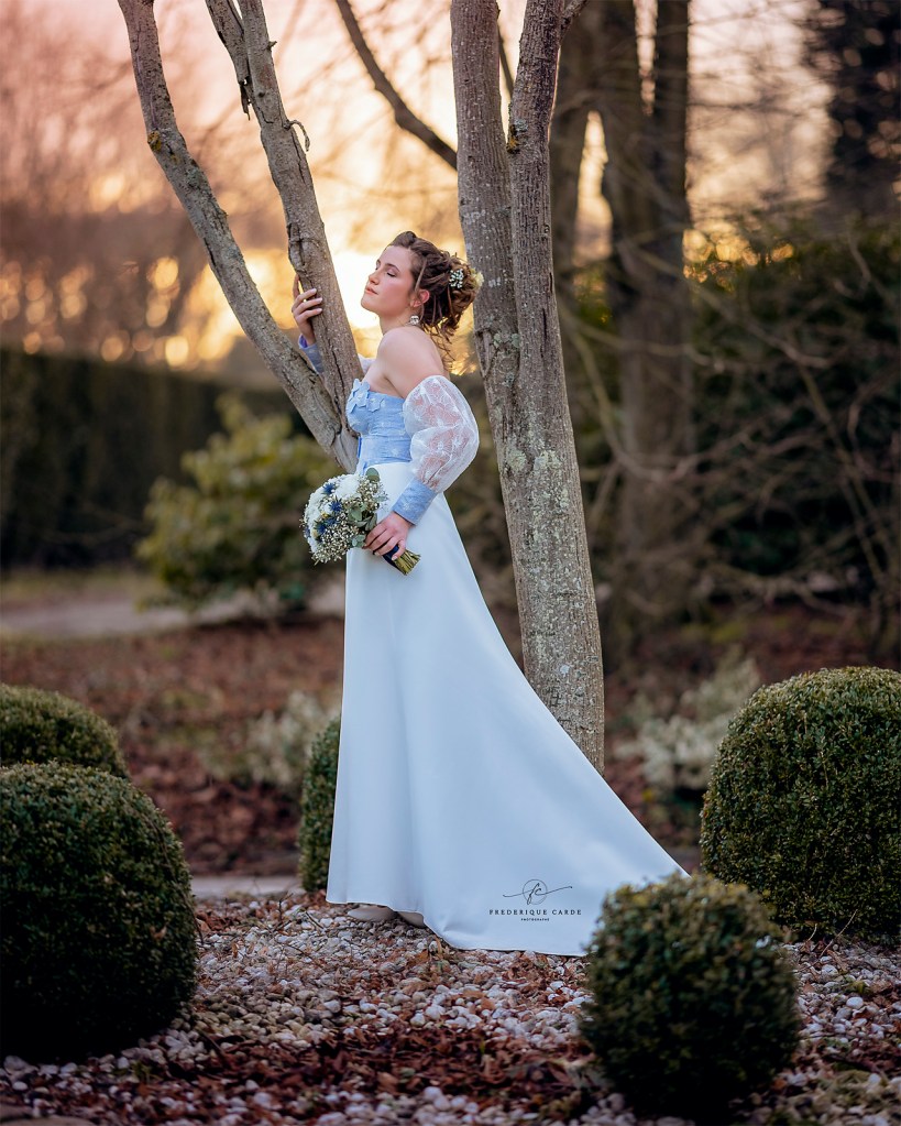 Robe de mariée en satin duchesse blanc cassé et doupion lavande, ornée de fleurs.