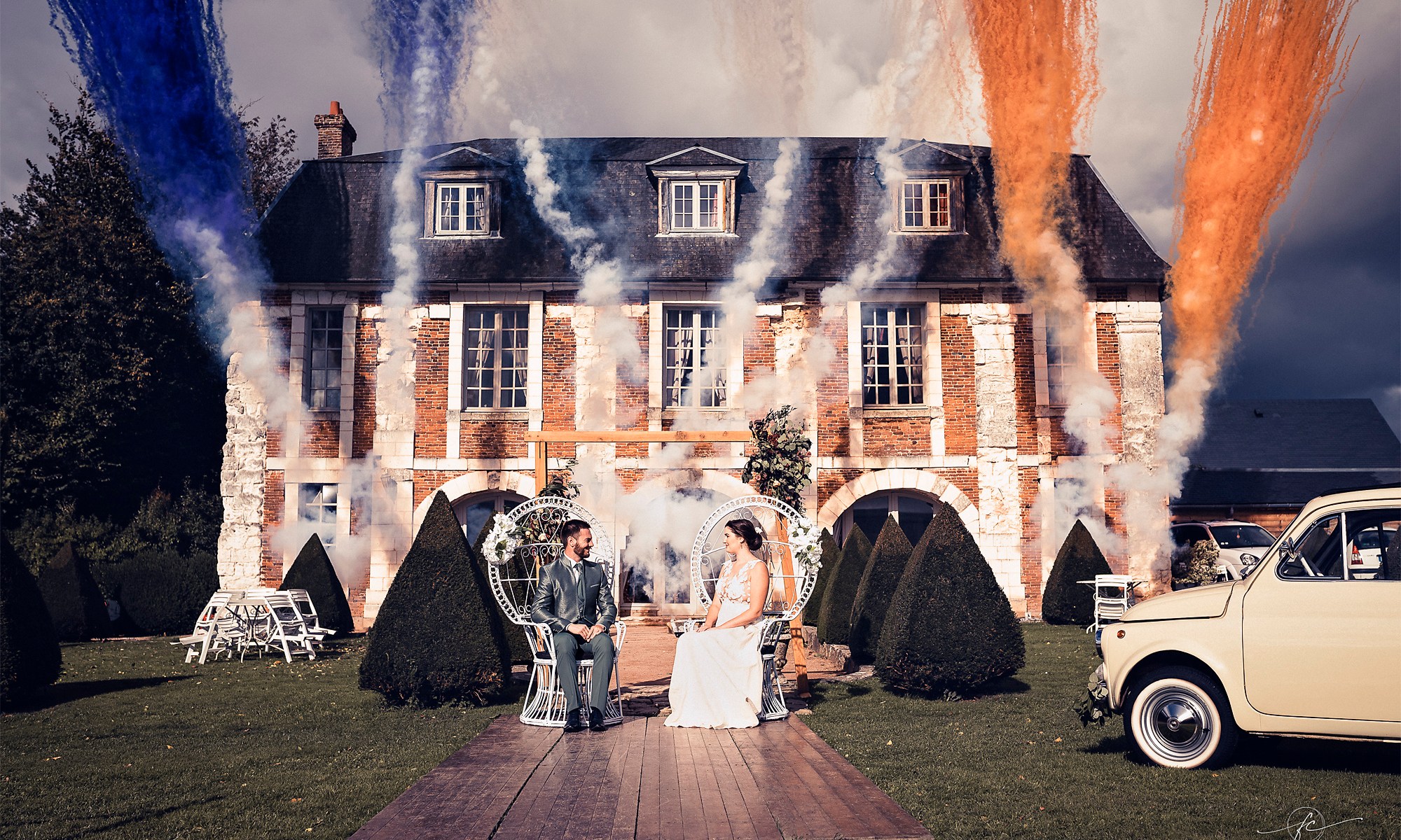 Photo de Frédérique Carde. Mariés devant l'Orangerie avec un feux d'artifice de jour.